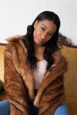 Kürklü güzel kadın, kanepede dinleniyor.