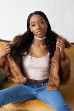 Kürklü güzel kadın, kanepede dinleniyor.