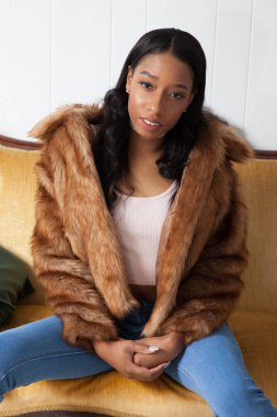 Kürklü güzel kadın, kanepede dinleniyor.