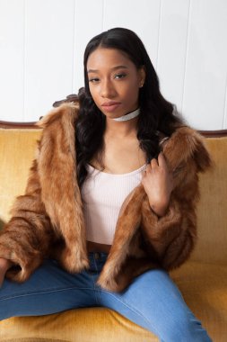 Kürklü güzel kadın, kanepede dinleniyor.