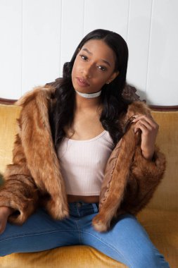 Kürklü güzel kadın, kanepede dinleniyor.