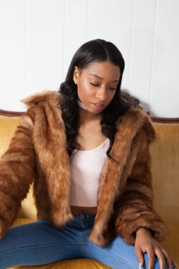 Kürklü güzel kadın, kanepede dinleniyor.