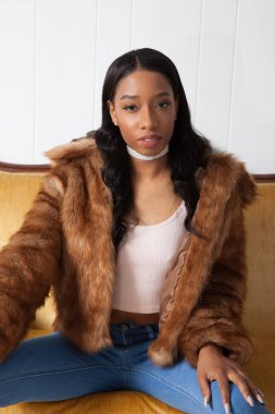 Kürklü güzel kadın, kanepede dinleniyor.