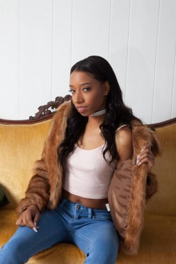 Kürklü güzel kadın, kanepede dinleniyor.