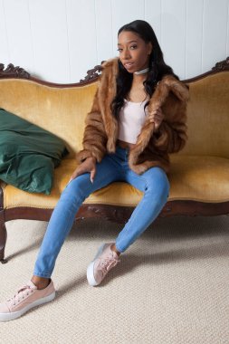 Kürklü güzel kadın, kanepede dinleniyor.