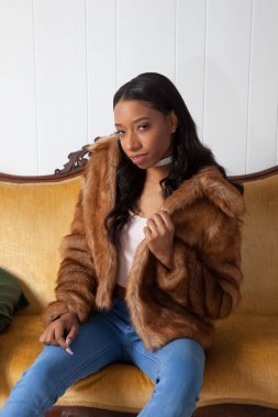 Kürklü güzel kadın, kanepede dinleniyor.