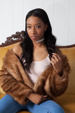Kürklü güzel kadın düşünceli bir şekilde oturuyor.