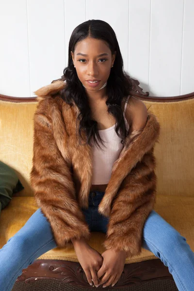 Kanepede oturan kürklü düşünceli kadın.