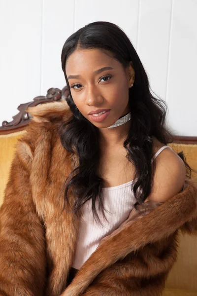 Kürklü güzel kadın, kanepede dinleniyor.