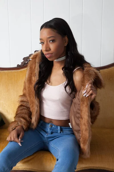 Kürklü güzel kadın, kanepede dinleniyor.