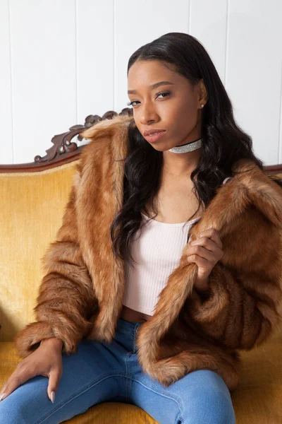 Kürklü güzel kadın, kanepede dinleniyor.