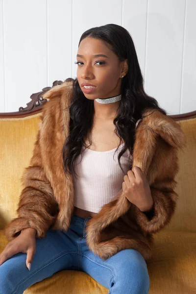 Kürklü güzel kadın, kanepede dinleniyor.