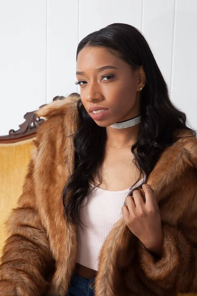 Kürklü güzel kadın, kanepede dinleniyor.