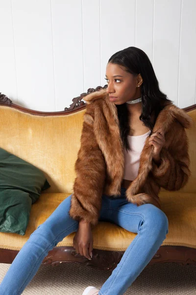 Kürklü güzel kadın düşünceli bir şekilde oturuyor.