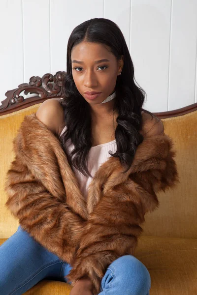Kürklü güzel kadın düşünceli bir şekilde oturuyor.