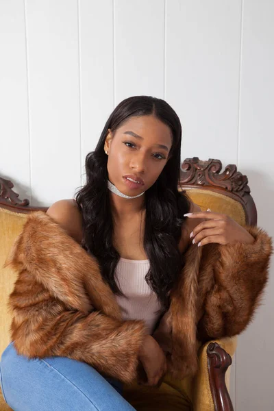 Kürklü güzel kadın düşünceli bir şekilde oturuyor.