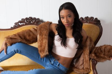 Güzel bir kadın kanepede dinleniyor ve düşünceli görünüyor.