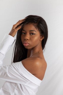 Güzel siyah kadın. Eli saçında.