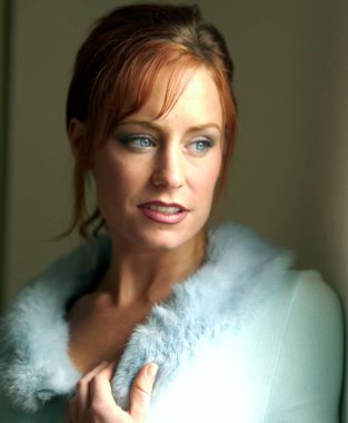 Güzel genç kadın mavi gözleri yumuşak ifade - düz saçları Kızıl - siyah eyeliner ve pembe ruj ve hafif hafif Erik dudak parlatıcısı sağa arıyorsunuz çarpıcı ışık mavi bulanık Yaka Kazak