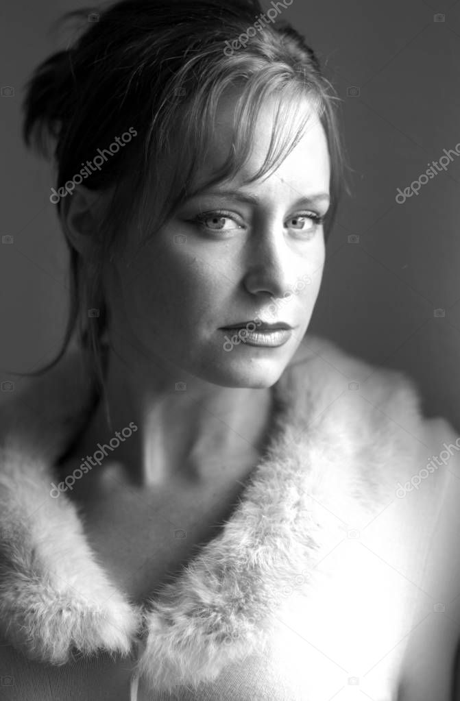 Beautiful young woman with stunning  eyes looking directly at camera with soft expression - straight hair  - black eyeliner and  lipstick and subdued light lip gloss Black and white gray scale monochrome 