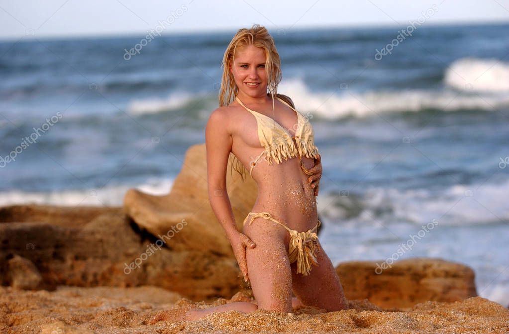 Ocean copy space background, sea waves text area, foreground sand copy space - travel to relaxing beach in an tropical island - Native American Indian leather adorable bikini on sea side rocks with blue warm waves in the golden light sunset 