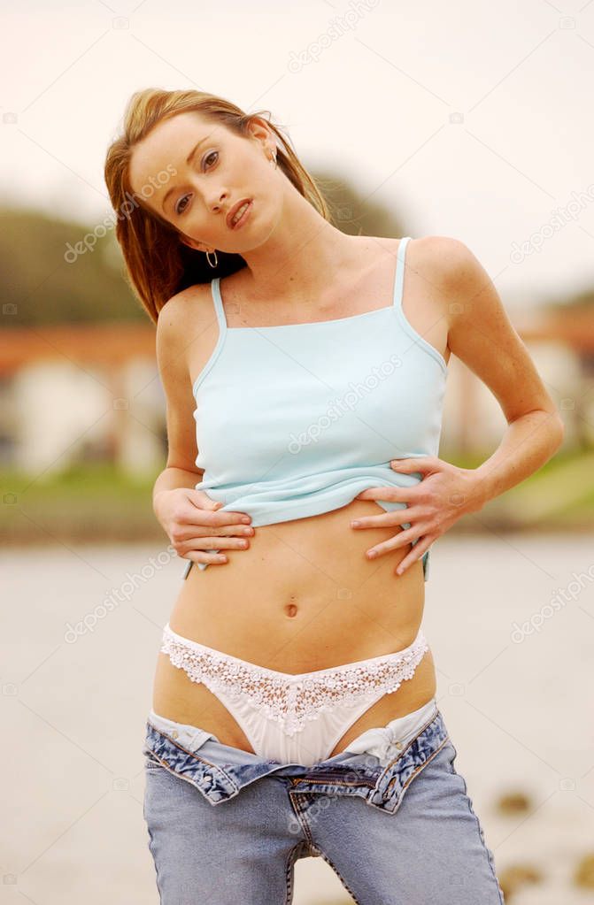 Tall thin trim toned female torso wears blue top blue jean skirt while on vacation and travel to paradise islands near hotel playa beach ocean side and sea shore - soft expressions natural looks bare arms shoulders - adorable face - white lace panty