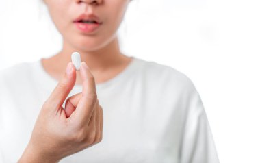 İlaç alan Asyalı kadının tedaviye ihtiyacı var. Beyaz arka plan, sağlıklı tedavi konsepti, seçici odaklanma..