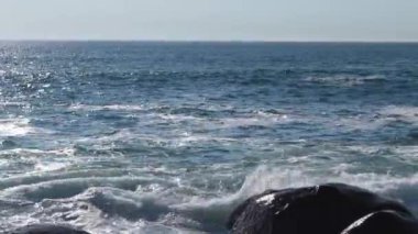 Güçlü okyanus dalgaları. Atlantik Okyanusu kıyısı. Kamera. Kıyı taşlarında kırılan dalgaların yakın çekimi.