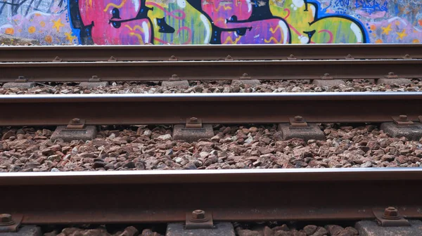 Demiryolu. Raylar. Graffiti.Raylar çok renkli grafitilerin arka planına yakın plan.