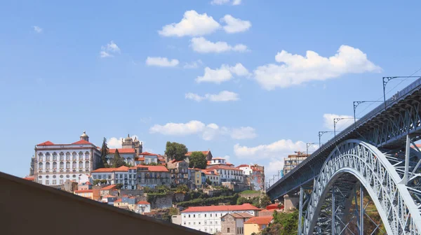Avrupa şehir manzarası. Porto 'nun merkezi ve Eyfel Köprüsü' nün manzarası. Gökyüzüne karşı kırmızı kiremitli çatılar ve resimli bulutlar..