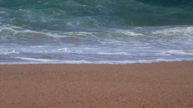 Kumlu sahilde el sallayın. Sahili yıkayan pitoresk bir dalganın görüntüsü. Yakın plan..