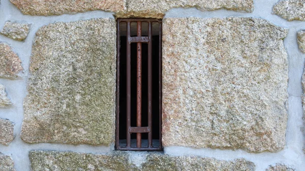 Dar bir kafes pencereli taş duvar. Arka plan, doku, desen..