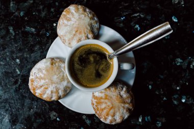 Taze zencefilli kurabiyelerin en üst görüntüsü mermer masada kaşıkla kahve fincanının etrafına yerleştirilmiş.