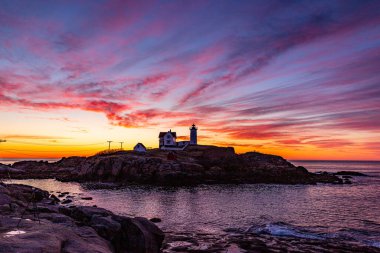 Okyanustaki deniz fenerinin üzerinden Samanyolu.