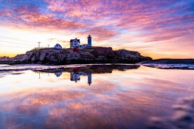 Okyanustaki deniz fenerinin üzerinden Samanyolu.