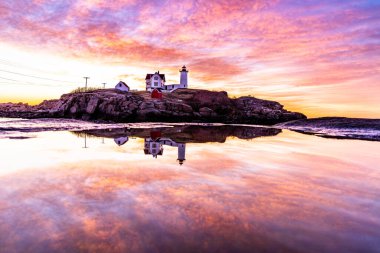 Okyanustaki deniz fenerinin üzerinden Samanyolu.