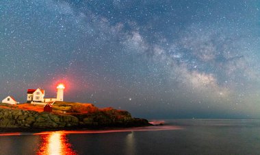Okyanustaki deniz fenerinin üzerinden Samanyolu.