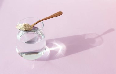 Arkaplanda kolajen tozu ve bir bardak su. Boşluğu kopyala.