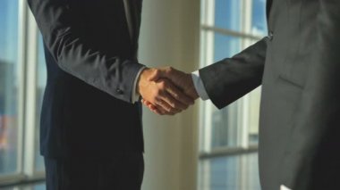 Ofis salonunda tokalaşan iki adam. yavaş çekim