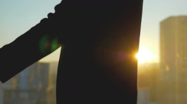 Günbatımı arka planında iki işadamı tokalaşıyor. yavaş çekim