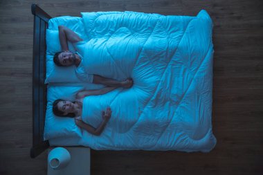 Yatakta uyuyan genç çift. Gece vakti. Yukarıdan görünüm