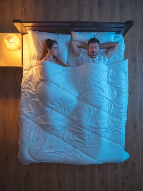 Yatakta uyuyan mutlu aşıklar. Akşam vakti. Yukarıdan görünüm