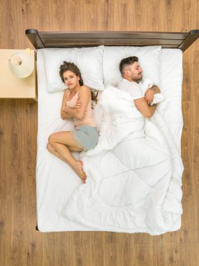 Kadın battaniyesiz bir adamın yanında yatıyordu. Yukarıdan görüntüle