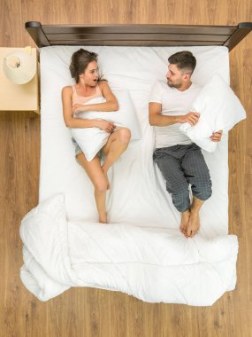 Çift yatakta yastık kavgası yapıyor. Yukarıdan görüntüle