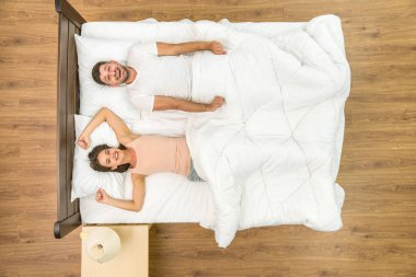 Yatakta uyanık olan çift. Yukarıdan görüntüle