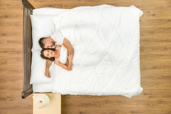 这对幸福的夫妇睡在床上 从上面看 — 图库照片