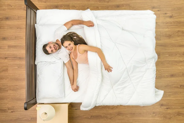 这对快乐的夫妇看着床上的摄像机 从上面看 — 图库照片