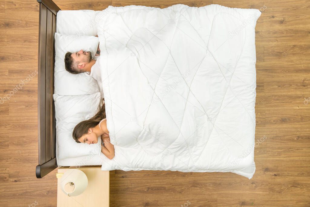 The couple sleeping in a white linens. View from above