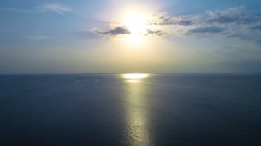 Şafak arkaplanındaki su yüzeyinin üzerindeki uçuş. Kuadrokopter görüntüsü