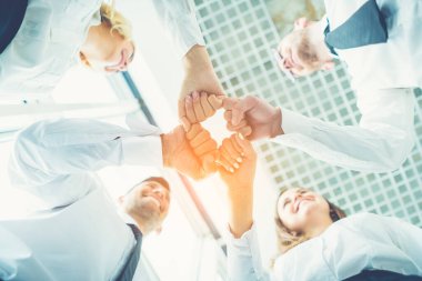 Dört mutlu iş adamı güneşli arka planda bir yumrukla selamlaşıyor.